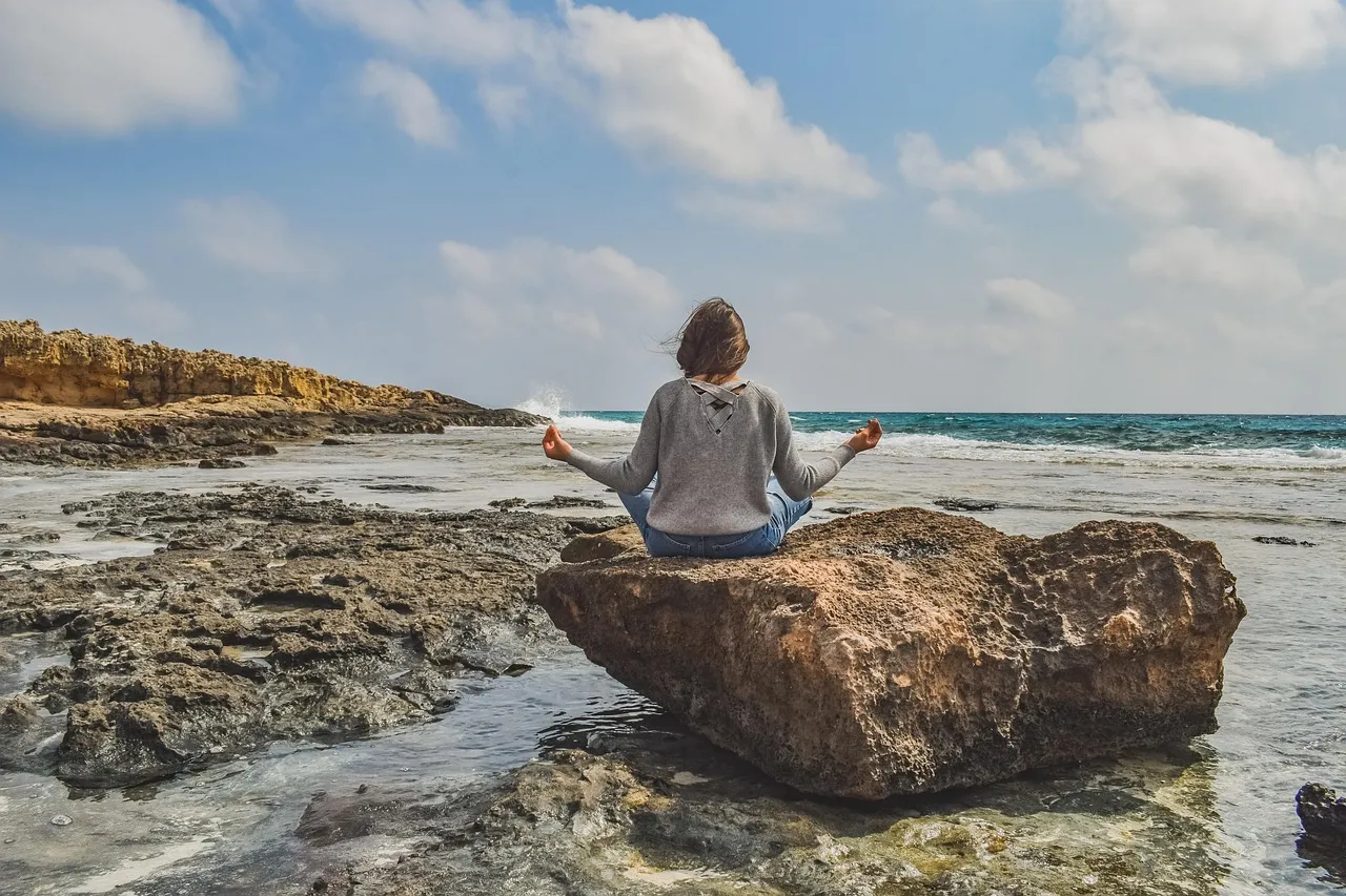 Person sitting quietly in nature practicing mindful breathing, reflecting the calming effect measured in mood studies