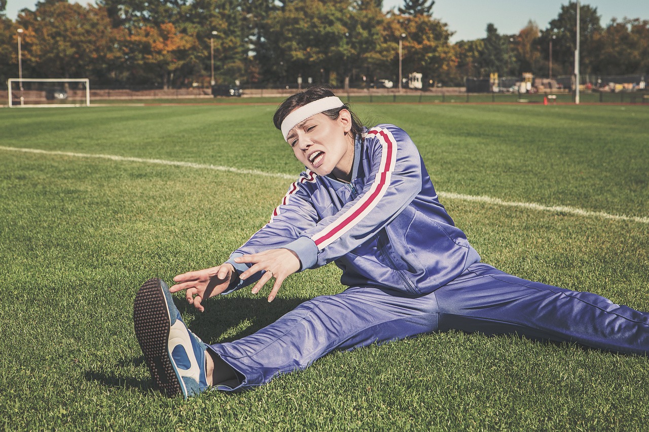 Athlete stretching outdoors on grass before or after a training session