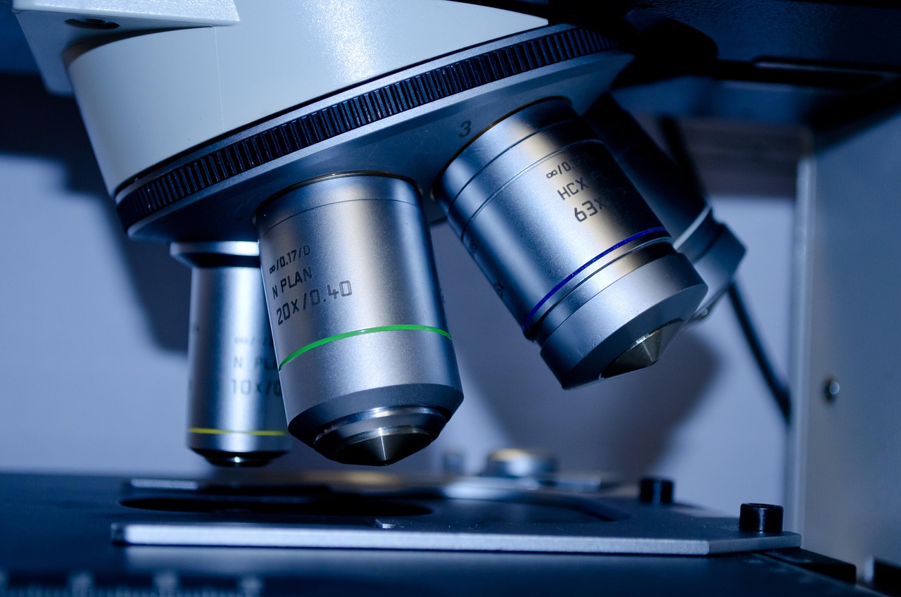 Researcher in a clinical laboratory reviewing test tube samples on a lit panel