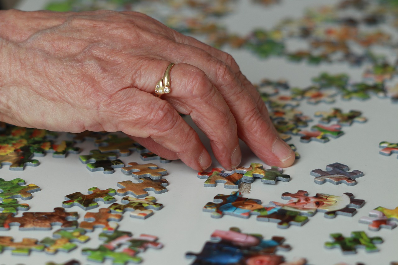 A senior woman working on a jigsaw puzzle, a mentally engaging hobby linked to cognitive reserve