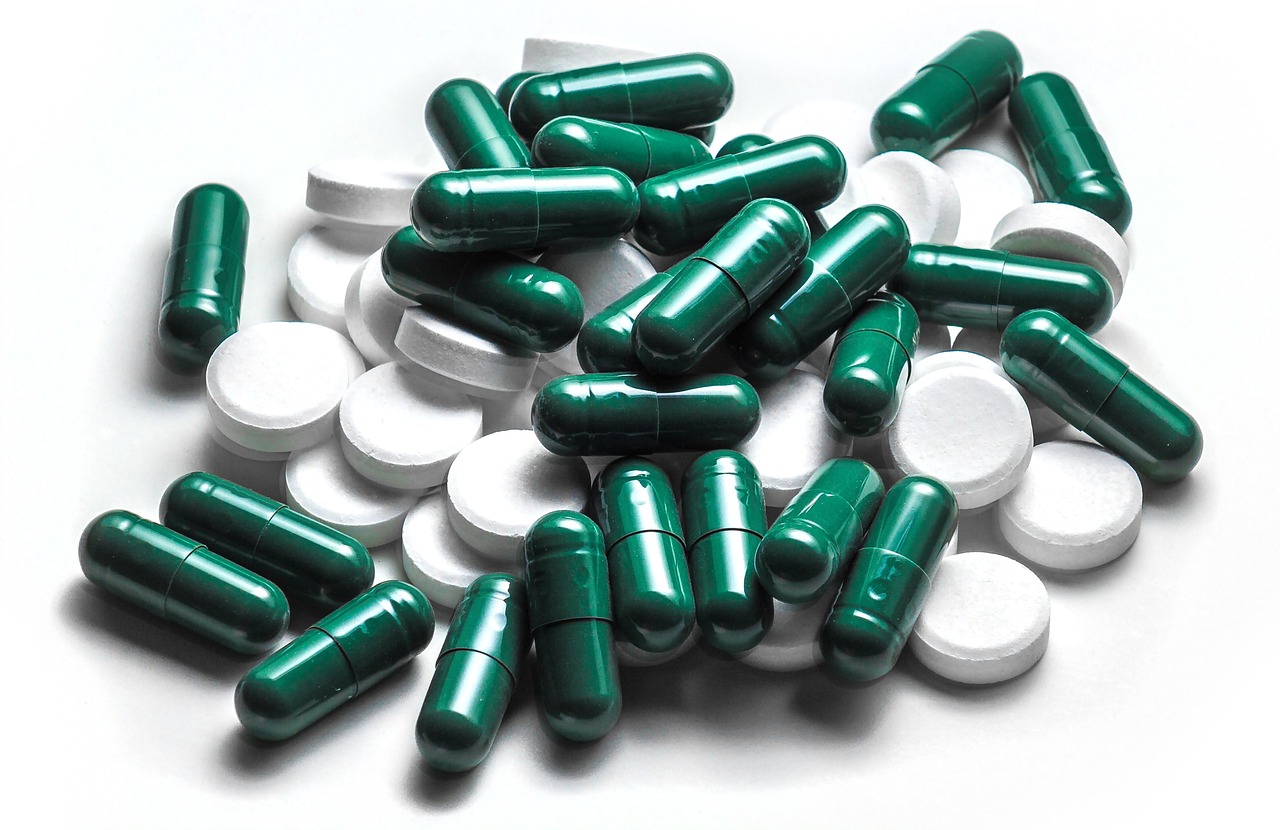 Pharmacist organizing prescription medications on dispensary shelves