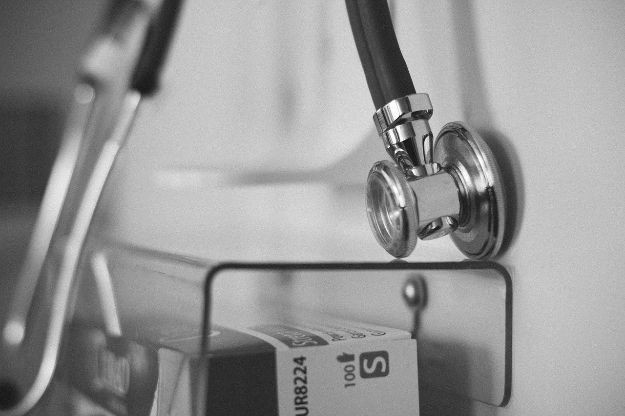 Doctor checking a patient’s blood pressure with a stethoscope during a clinical exam
