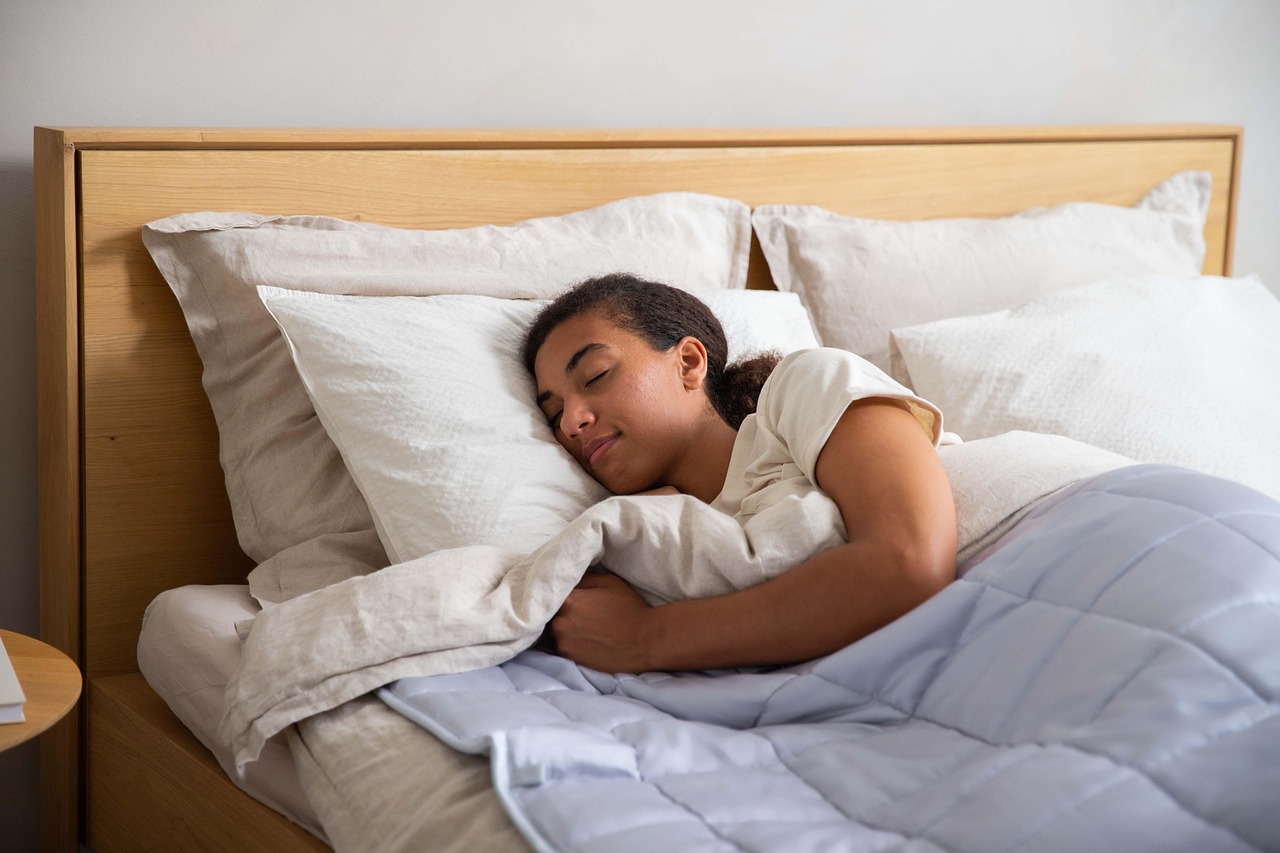 Woman, bed, blanket — illustrating Sleep Consistency vs Sleep Duration