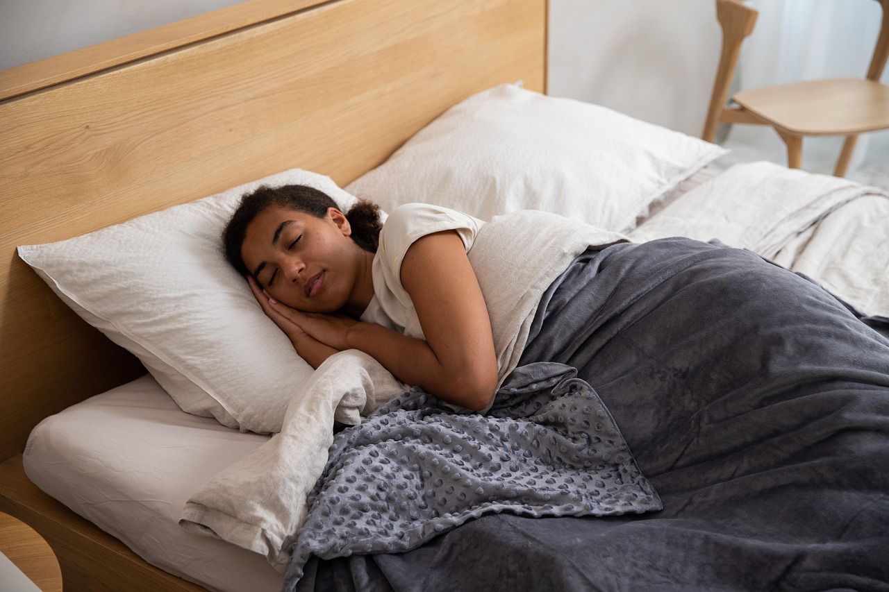Woman, bed, blanket — illustrating Why Sleep Beats Every Recovery Gadget